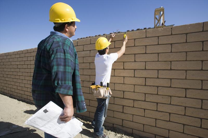 men installing concrete wall