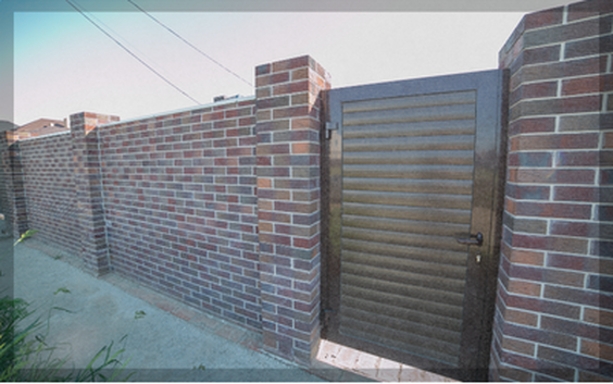 Custom entry gate installed in a block wall