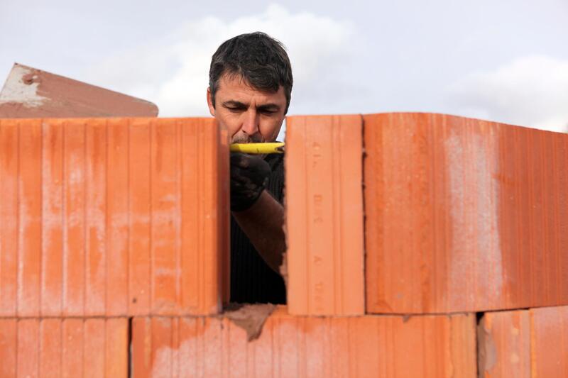 man installing brick veneer